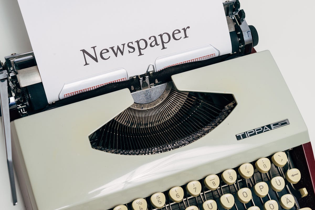 Vintage typewriter printing newspaper - representing the journalism roots of AP style headline capitalization
